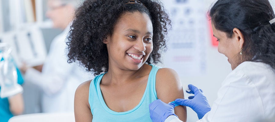 pediatrician giving shot to girl