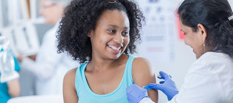 pediatrician giving shot to girl